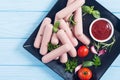 Raw beef sausages with pepper , herbs and ketchup Royalty Free Stock Photo