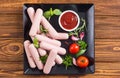 Raw beef sausages with pepper , herbs and ketchup Royalty Free Stock Photo