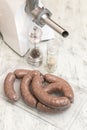 Raw beef sausages on wooden table close up. Meat grinder for cooking minced meat and spices to add spice to dish. Production of Royalty Free Stock Photo