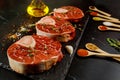 Raw beef shank and spices for preparing ossobuco dish on black background Royalty Free Stock Photo