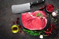 Raw beef steak on black background with cooking ingredients. Fresh beef meat