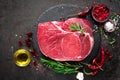 Raw beef steak on black background with cooking ingredients. Fresh beef meat