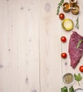 Raw beef steak with butter and spices, laid out around it, border ,place for text wooden rustic background top view close up Royalty Free Stock Photo