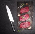 Raw beef steak on a cutting board with rosemary and cherry tomatoes. Royalty Free Stock Photo