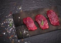 Raw beef steak on a cutting board with rosemary and spices. Royalty Free Stock Photo