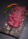 Raw beef steak on a cutting board with rosemary and spices. Royalty Free Stock Photo