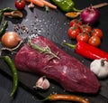 Raw beef steak on a cutting board with rosemary and spices. Royalty Free Stock Photo