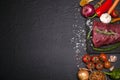 Raw beef steak on a cutting board with rosemary and spices. Royalty Free Stock Photo