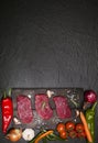 Raw beef steak on a cutting board with vegetables and spices. Royalty Free Stock Photo