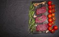 Raw beef steak on a cutting board with vegetables and spices. Royalty Free Stock Photo