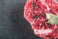 Raw beef steak fillet with ingredients like sea salt and pepper and bay leaves on black board, image for restaurant, Royalty Free Stock Photo