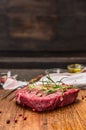 Raw beef steak with ingredients for cooking on rustic kitcen table over dark woden background Royalty Free Stock Photo