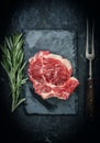 Raw beef steak with rosemary on stone plate. Royalty Free Stock Photo