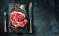 Raw beef steak with salt and herbs on the stone plate. Royalty Free Stock Photo