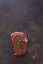 Raw beef steak on stone background garnished with rosemary