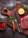Raw beef steak with vegetables. Horizontal view of red meat on wooden cutting board.