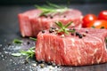 Raw Beef Steaks with spices and Rosemary over Slate