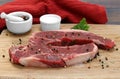 Raw beef strip steaks on a cutting board.