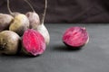 Raw beetroot and two halves on black background, side view. Royalty Free Stock Photo