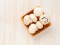 Raw big fresh champignon mushrooms in wooden bowl on a white background, top view Royalty Free Stock Photo