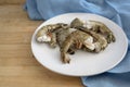 Raw black tiger prawn shrimps without head, fresh cooking ingredients for a tasty dish, white plate, blue napkin and a wooden Royalty Free Stock Photo