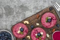 Raw blueberry and acai vegan cakes with fresh berries, mint, nuts. healthy vegan food concept. top view