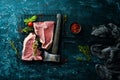 Raw bone steak with an ax. Top view. Royalty Free Stock Photo