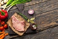 Raw bone steak on paper with vegetables Royalty Free Stock Photo