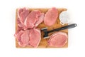 Raw boneless pork loin chops and meat tenderizer on a wooden cutting board Royalty Free Stock Photo