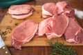 Pork Loin chops on wooden cutting board with some herbs, salt, and rosemary Royalty Free Stock Photo