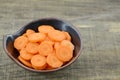 Cuts sliced of carrot in bowl on wooden background Royalty Free Stock Photo