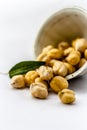 Raw bright dark brown colored Desi chana or original chickpea in a glass bowl isolated on white.