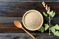 Raw brown quinoa seed in a bowl on wooden background