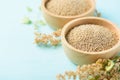 Raw brown quinoa seed in a wooden bowl