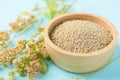 Raw brown quinoa seeds in wooden bowl