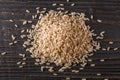 Raw brown rice on dark rustic wooden background