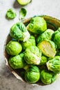 Raw brussels sprouts in bowl, gray concrete background, top view. Healthy vegan food concept