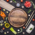 Raw buckwheat noodles with vegetables, ginger, chopsticks and ingredients, laid out around cutting board place for text,frame