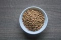 Raw Buckwheat in white ceramic bowl on wooden wood