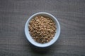 Raw Buckwheat in white ceramic bowl on wooden wood