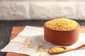 Raw bulgur in a clay bowl on a wooden board