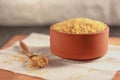 Raw bulgur in a clay bowl on a wooden board