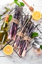 Raw Bunch of purple asparagus on a white wooden background. Healthy food. Top view, free copy space Royalty Free Stock Photo