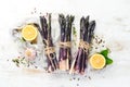 Raw Bunch of purple asparagus on a white wooden background. Healthy food. Top view, free copy space Royalty Free Stock Photo