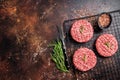 Raw burger cutlet from beef meat with spices and rosemary ready for cooking. Dark background. Top view. Copy space Royalty Free Stock Photo