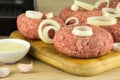 raw burgers, beef on a cooting board, frying pan on woogen background Royalty Free Stock Photo