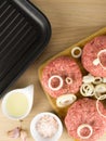 raw burgers, beef on a cooting board, frying pan on woogen background Royalty Free Stock Photo