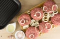 raw burgers, beef on a cooting board, frying pan on woogen background Royalty Free Stock Photo