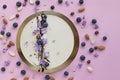 Raw cake decorated with blueberries, chocolate, nuts and lilac flowers on pink background. Gluten free, sugar free vegetarian food Royalty Free Stock Photo