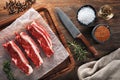 Raw calf short rib on white cooking paper and wooden cutting table